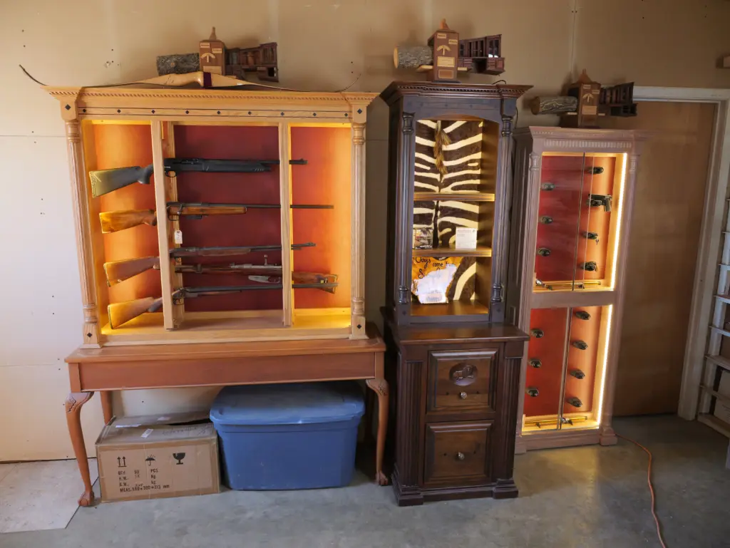 Custom display safes showcasing firearms with integrated lighting, elegant wooden cabinetry, and organized storage for secure preservation, reflecting aesthetic design and security for serious collectors.